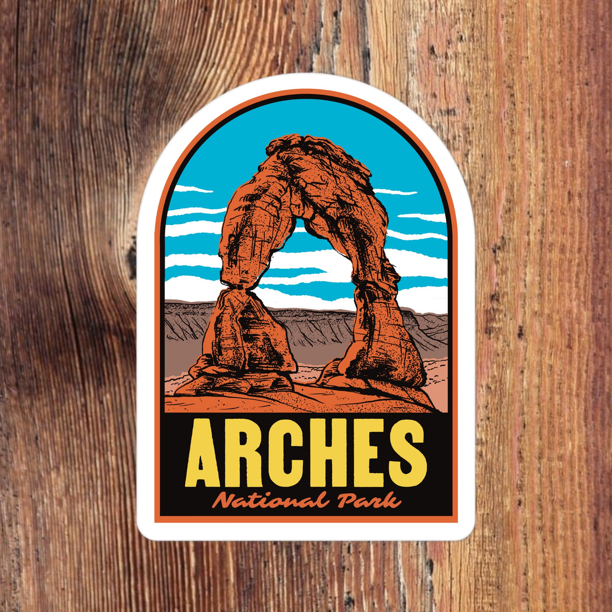 A sticker of Arches National Park on a wood background