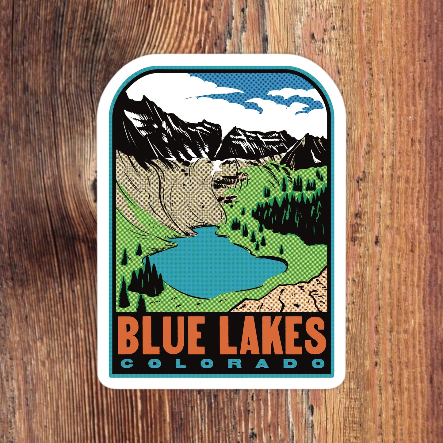 Sticker of Blue Lakes Colorado with a mountain and lake illustration on a wooden surface
