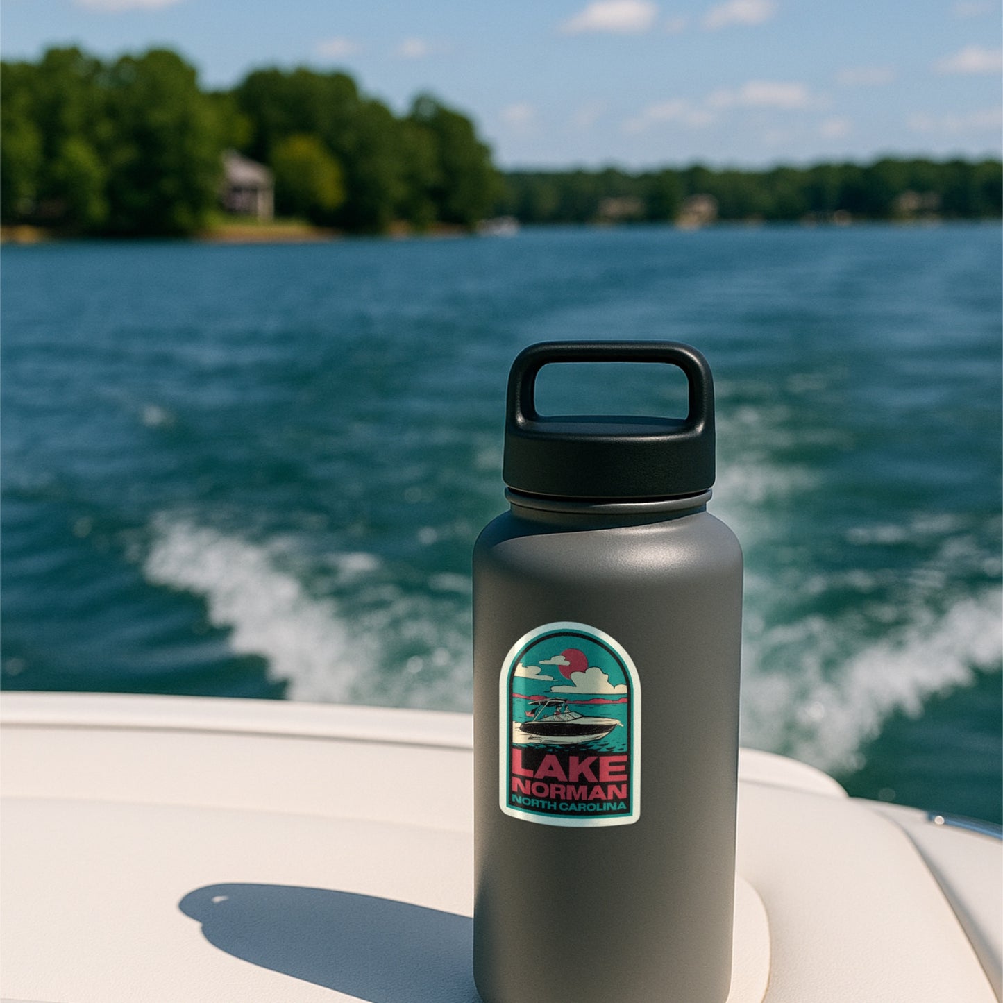 A sticker of Lake Norman in a retro style stuck to a water bottle on the back of a boat on the lake