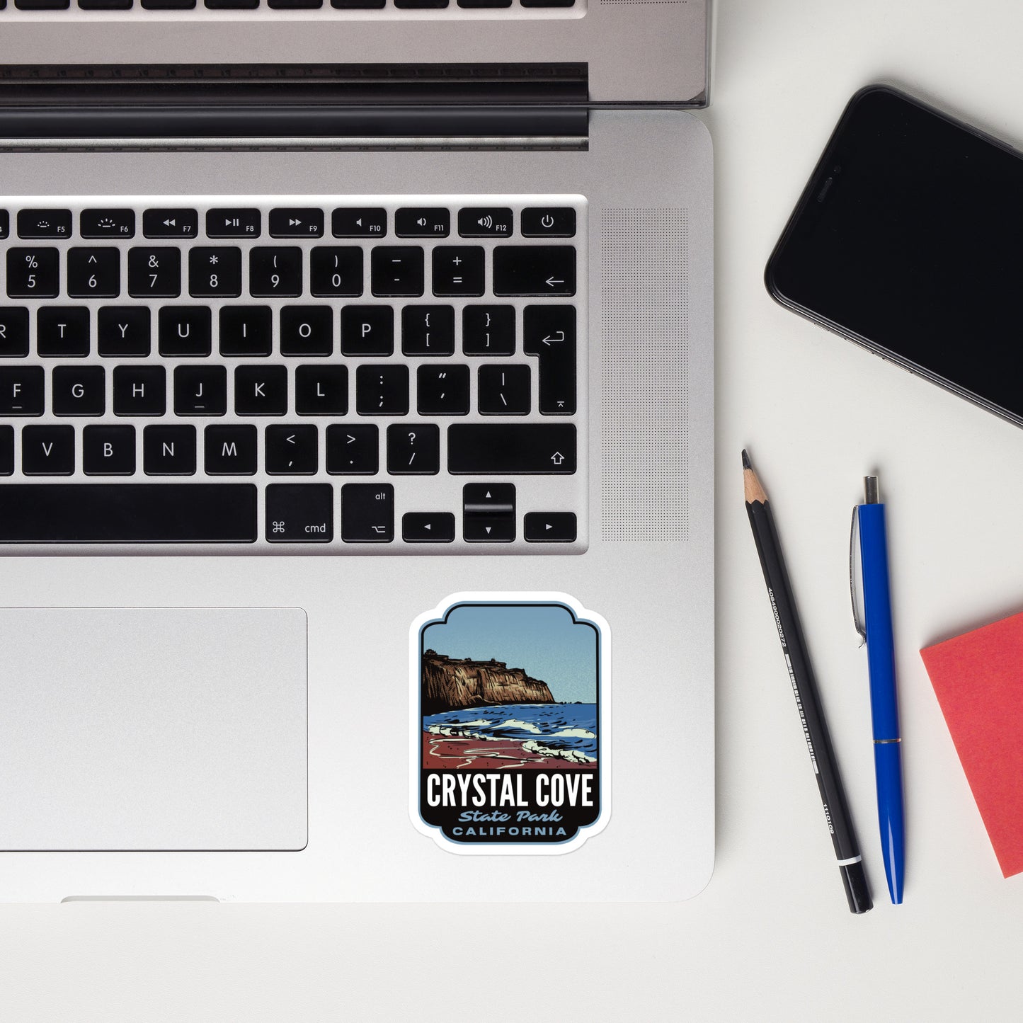 A sticker of Crystal Cove State Park on a laptop