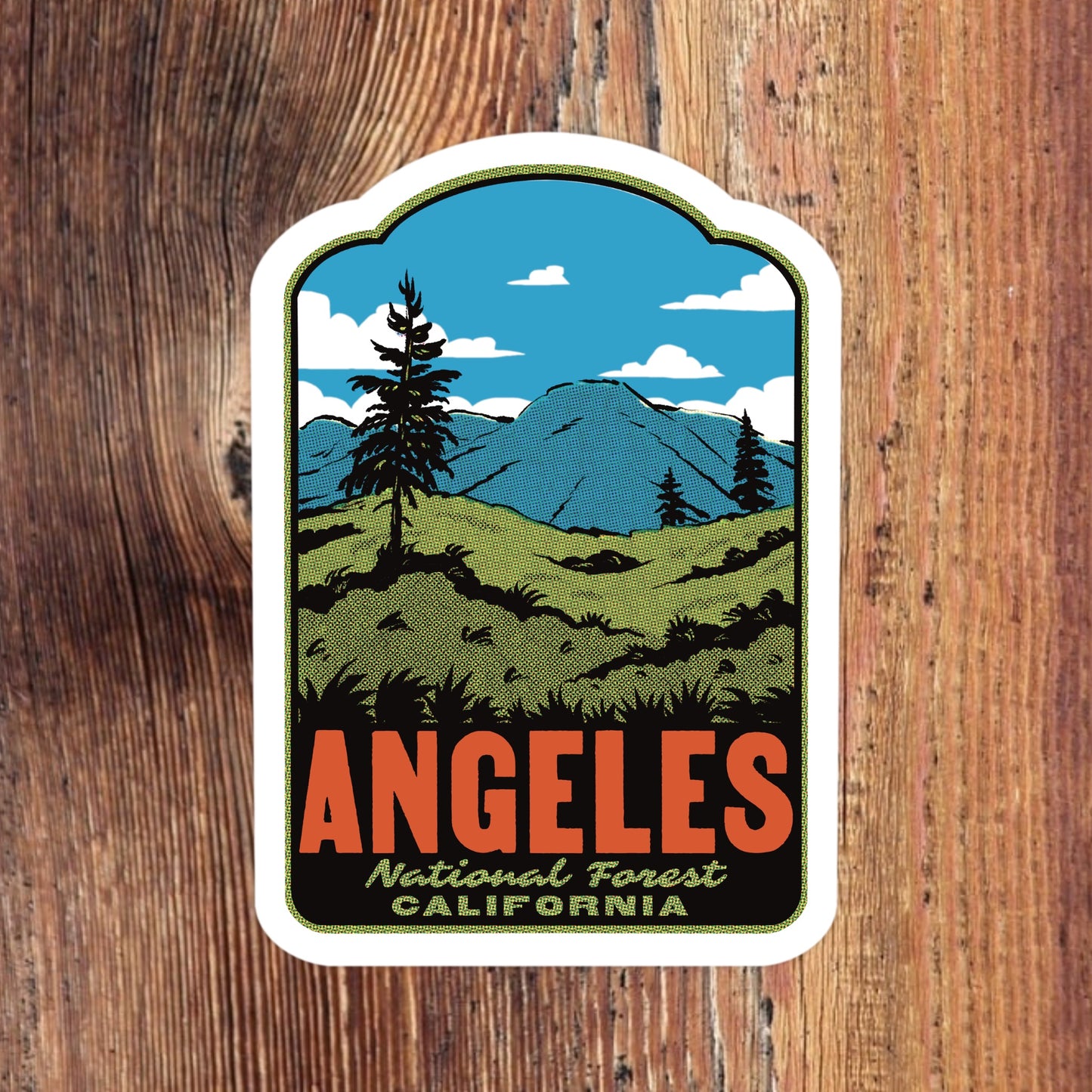 Sticker of Angeles National Forest with mountains and trees on a wooden background