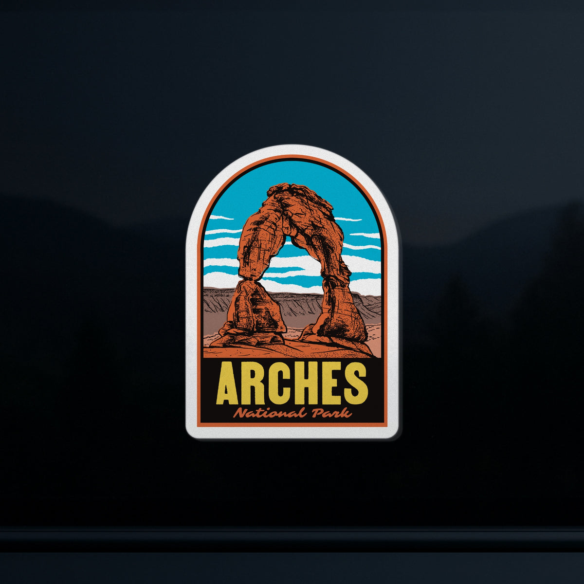 A sticker of Arches National Park on a car window