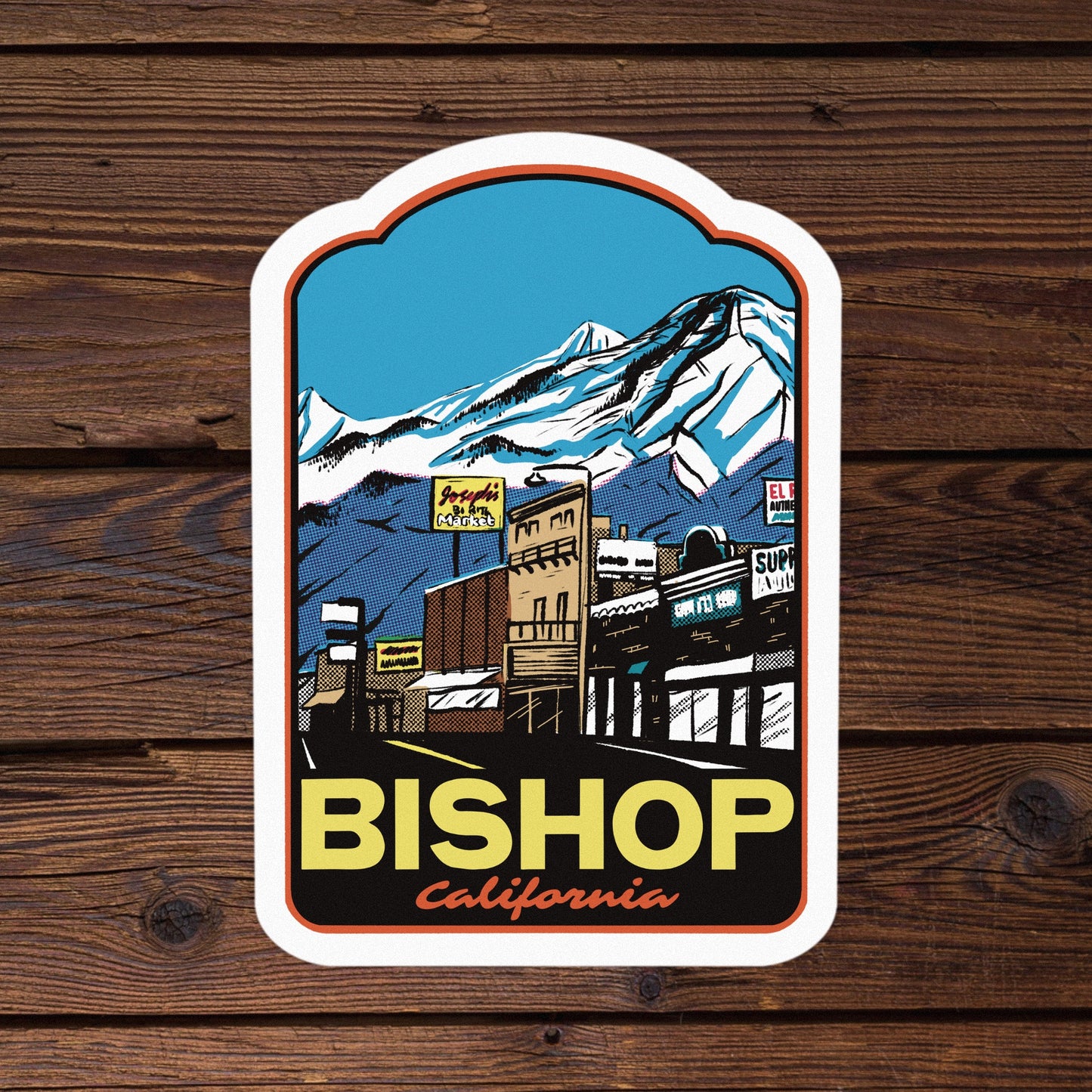 Sticker with a mountain and town design on a wooden background