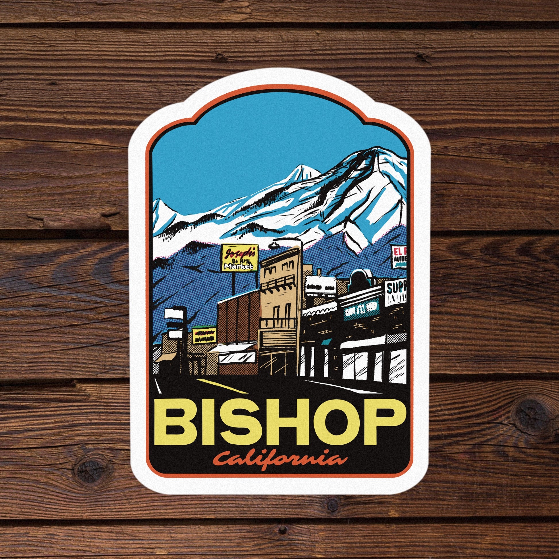 Sticker with a mountain and town design on a wooden background