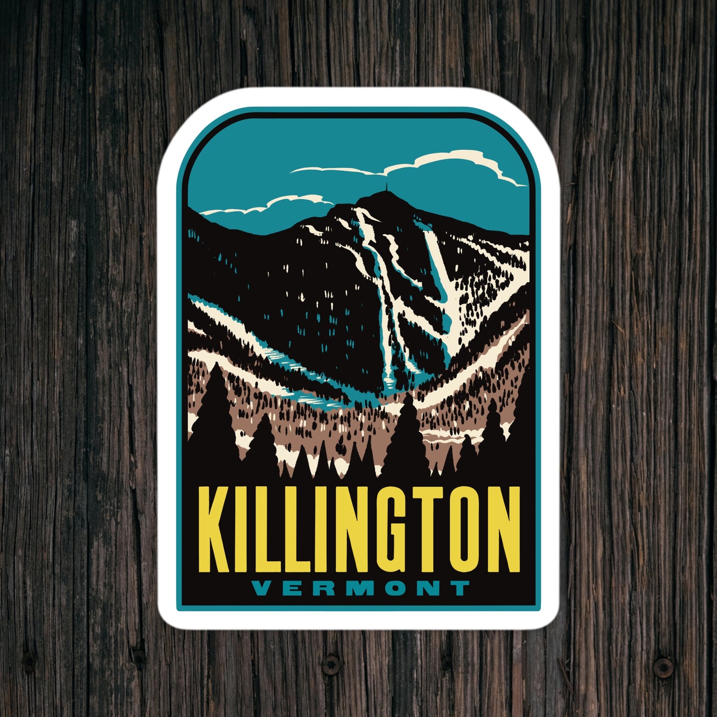 Sticker with mountain design and 'Killington Vermont' text on a wooden surface