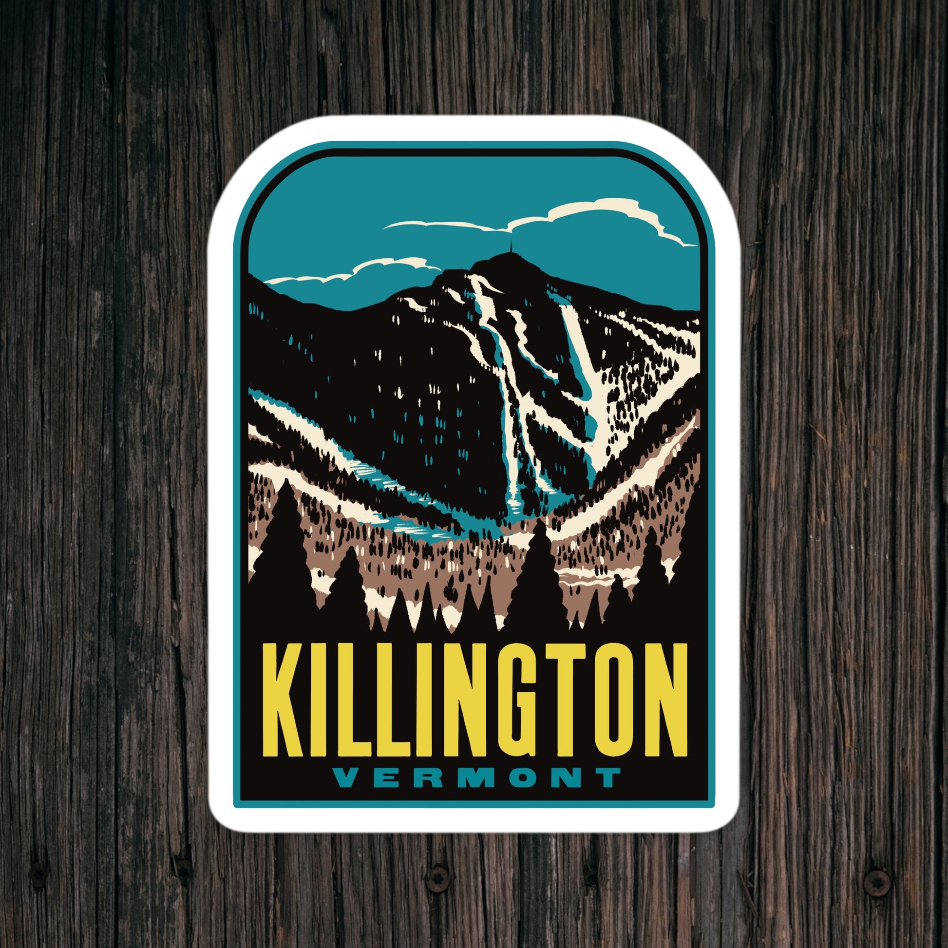Sticker with mountain design and 'Killington Vermont' text on a wooden surface