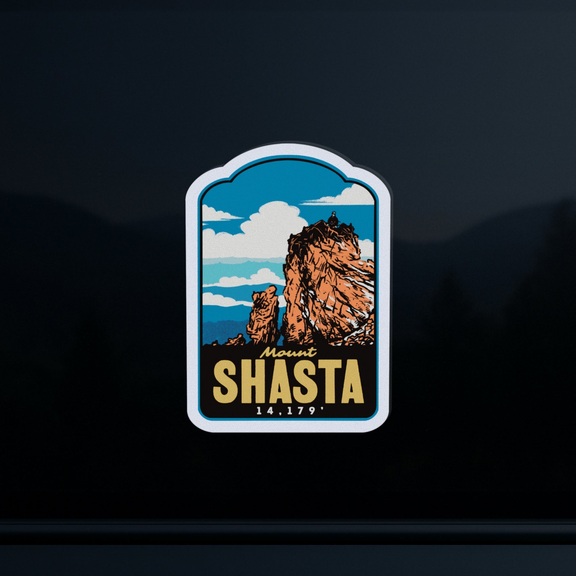 A die-cut sticker featuring a stylized illustration of Mount Shasta with the text 'Mount SHASTA 14,179' on a dark background.
