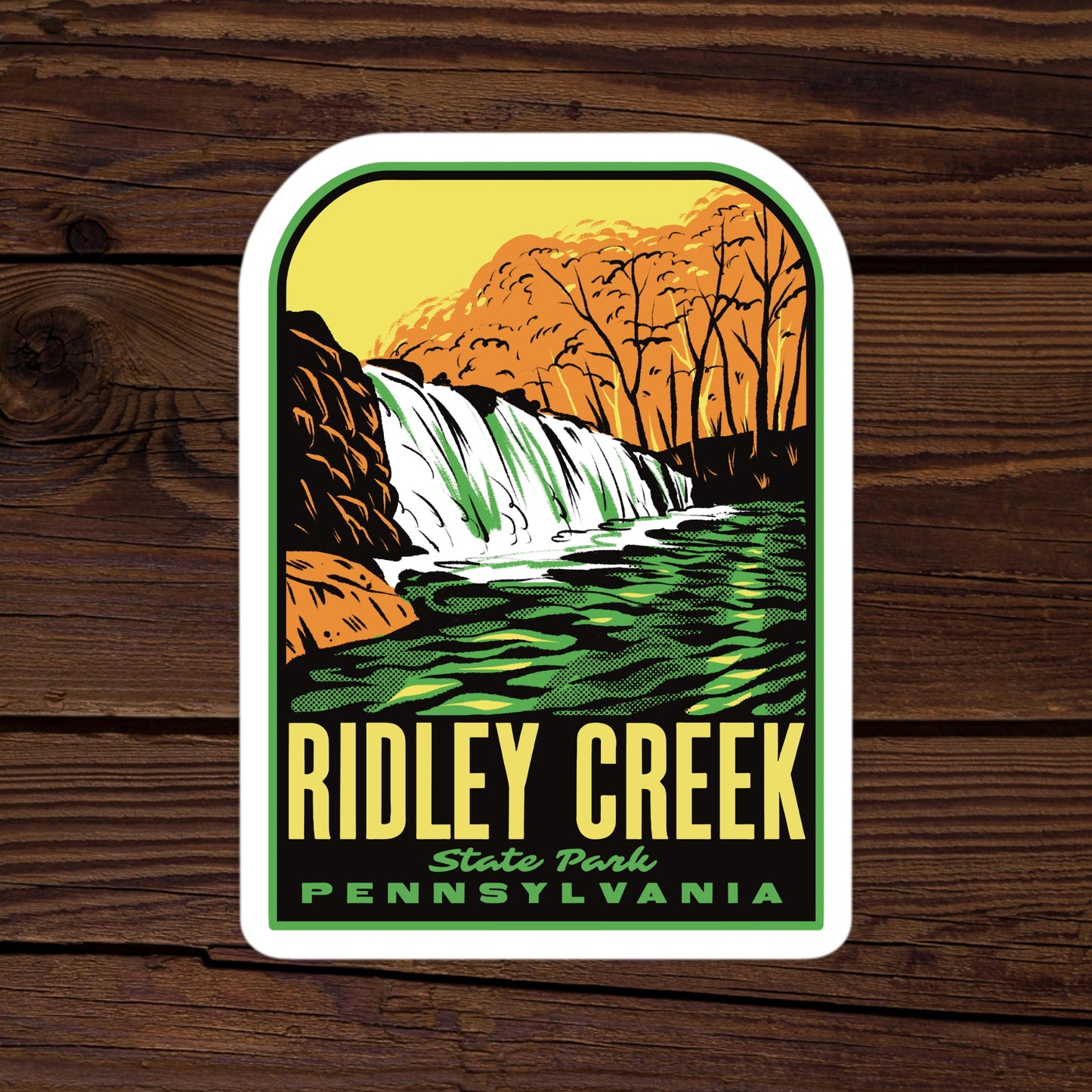Sticker of Ridley Creek State Park, Pennsylvania with a waterfall design on a wooden background.