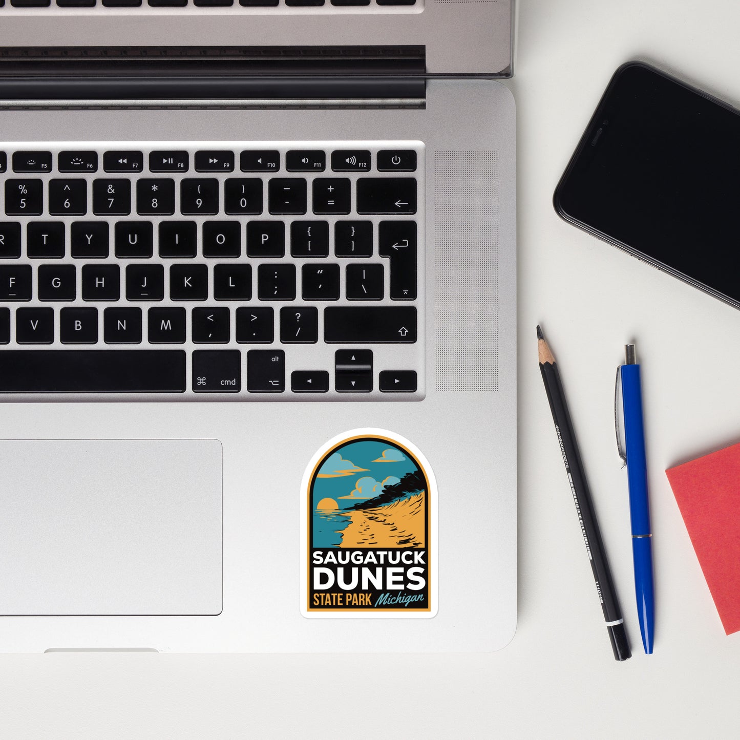 A sticker of Saugatuck Dunes State Park on a laptop